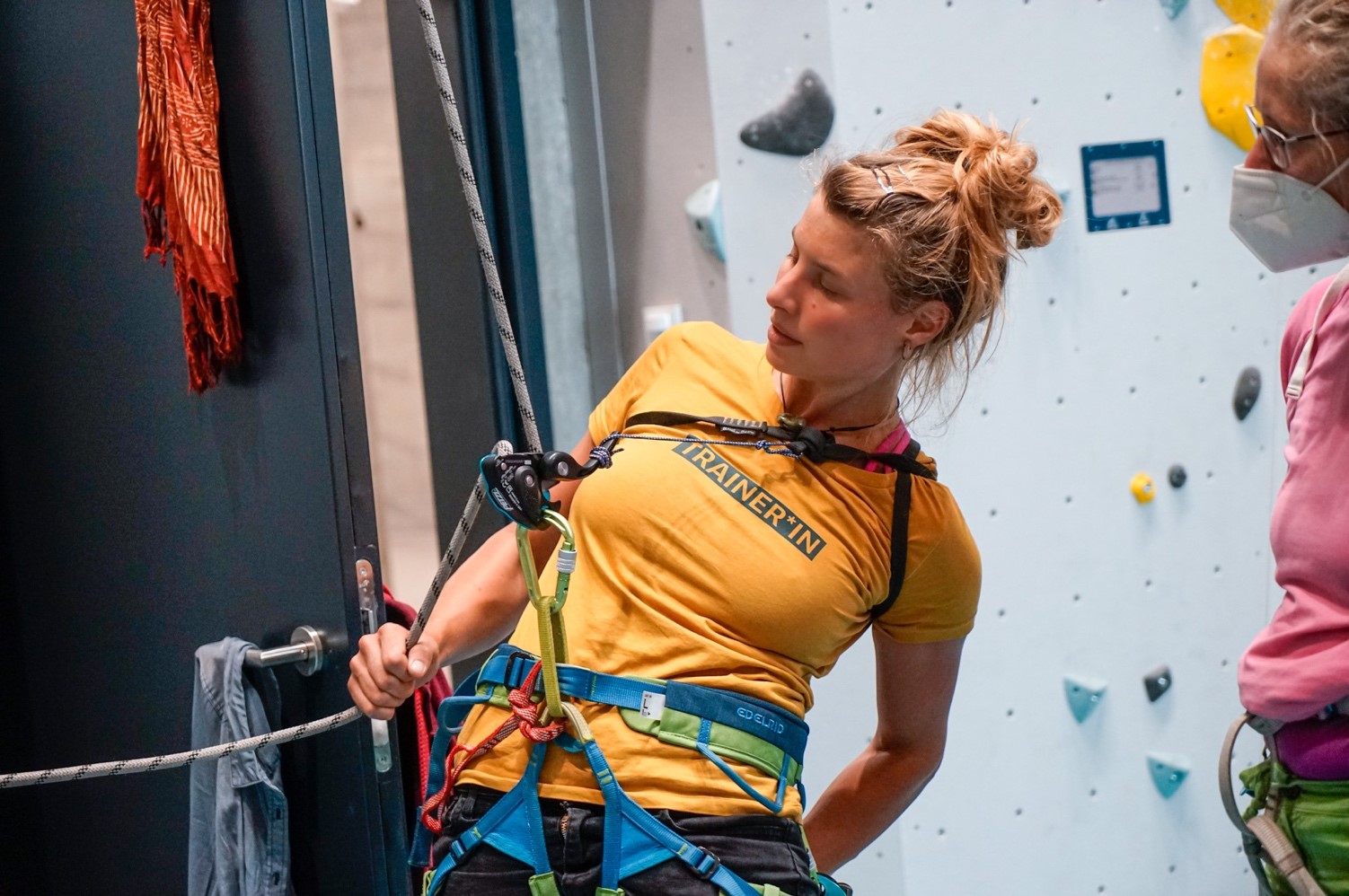 Klettertrainerin zeigt Seilhandling und Knotentechnik