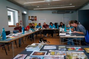 Workshop im Seminarraum, Teilnehmer sitzen an U-Form
